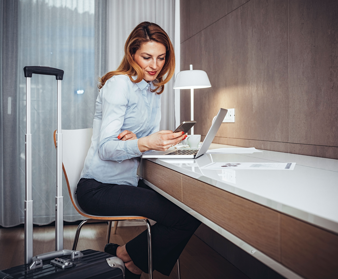 Woman looking at phone in hotel room